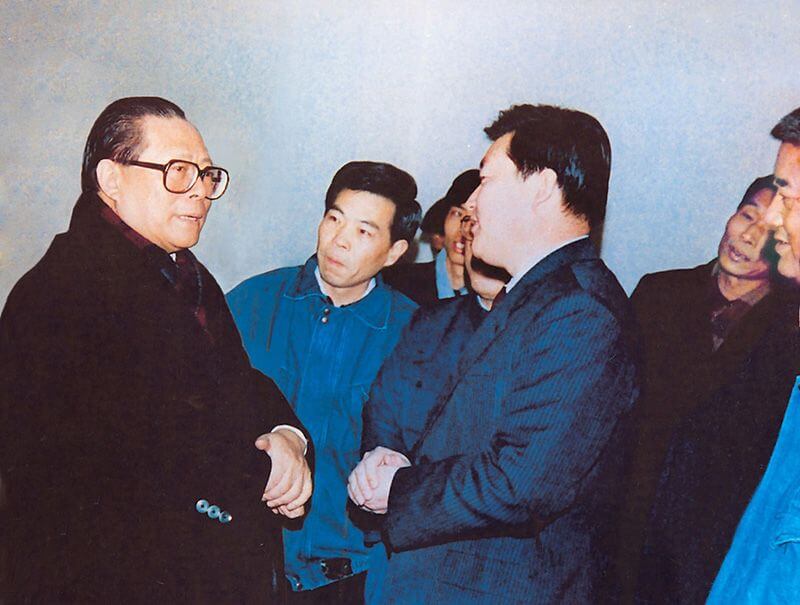 1991年2月5日，时任中共中央总书记的江 泽 民（左一）视察利来国际，他指示：“抓住机遇，深化改革，扩大开放，促进发展，保持稳定。”